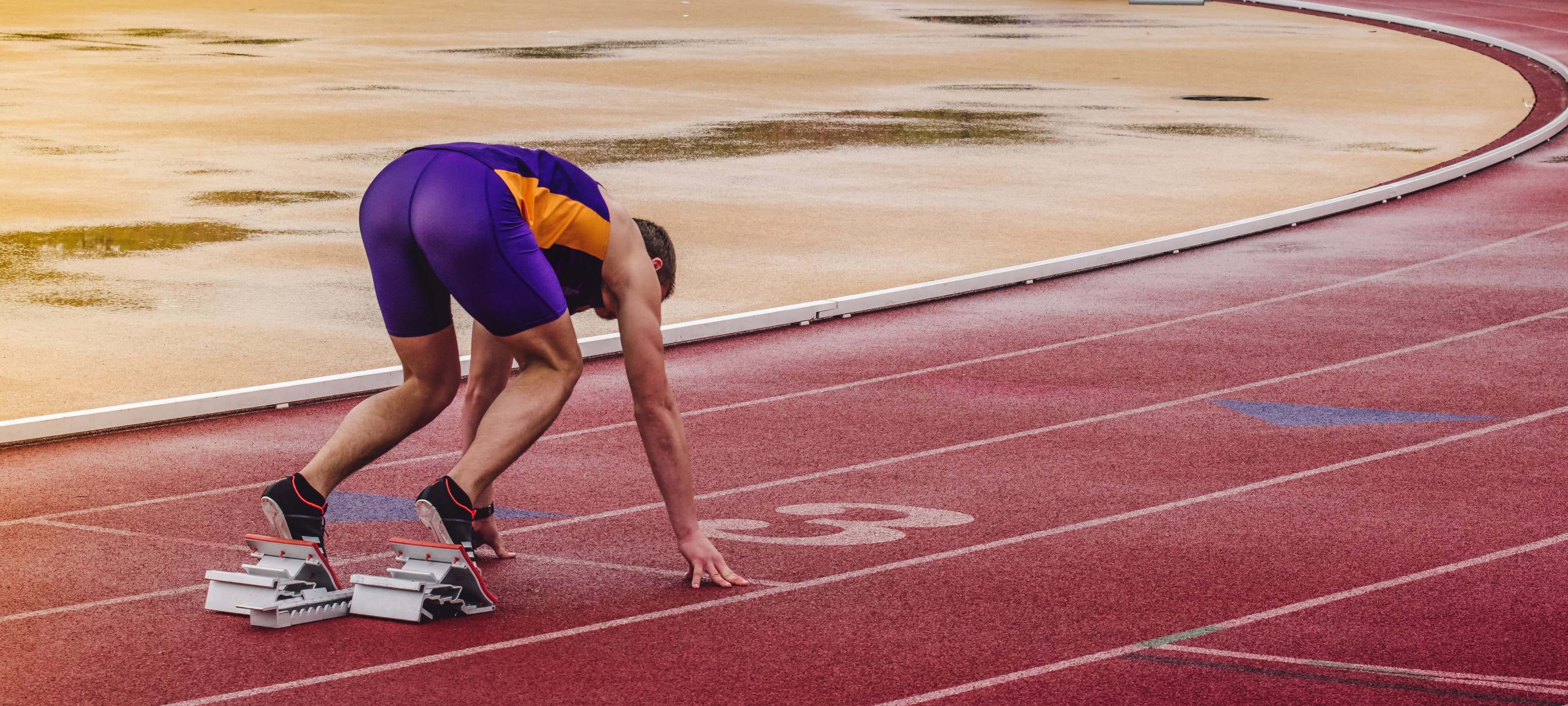 a runner is on the track about to take off from the starting point